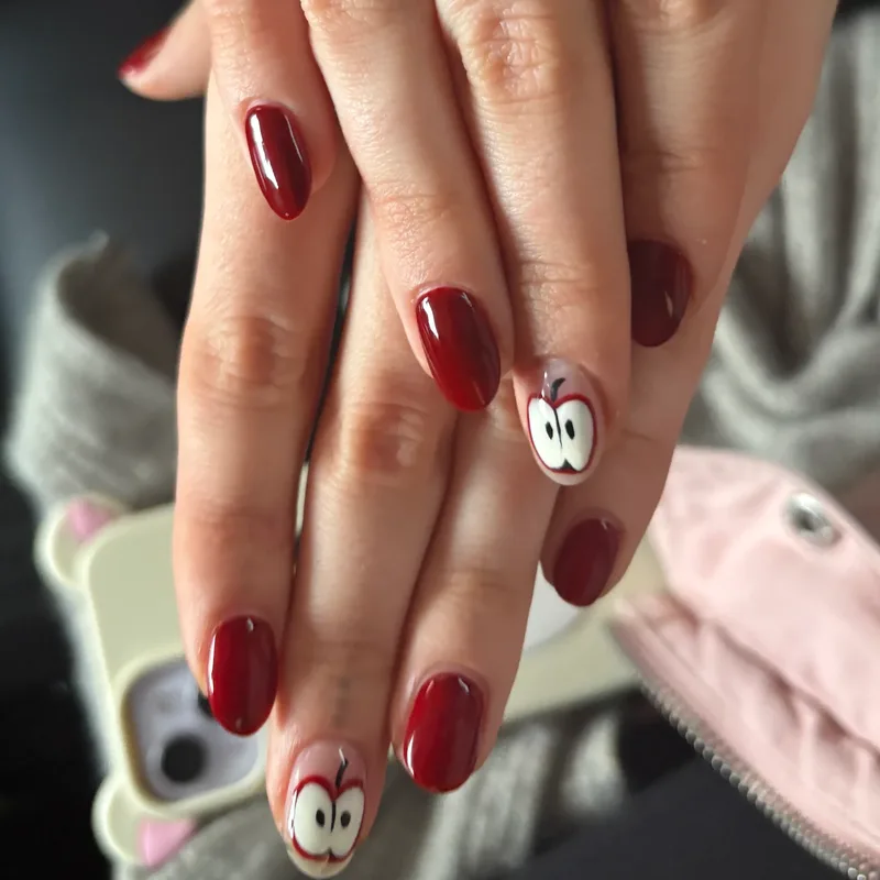Dark red almond nails with hand-painted cartoon art by Tina Green Nail