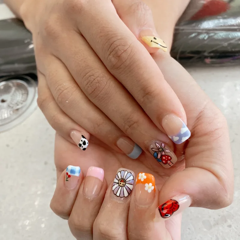 Playful mixed designs with charms and flowers by Tina Green Nail