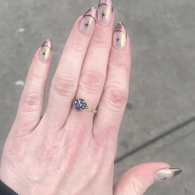 Aura chrome gel nails with gold French line and star accents on almond-shaped extensions, Brooklyn nail salon